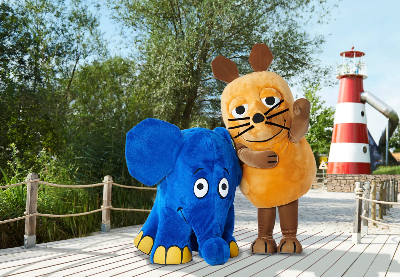 Topo ed Elefante al Ravensburger Spieleland davanti al faro rosso e bianco